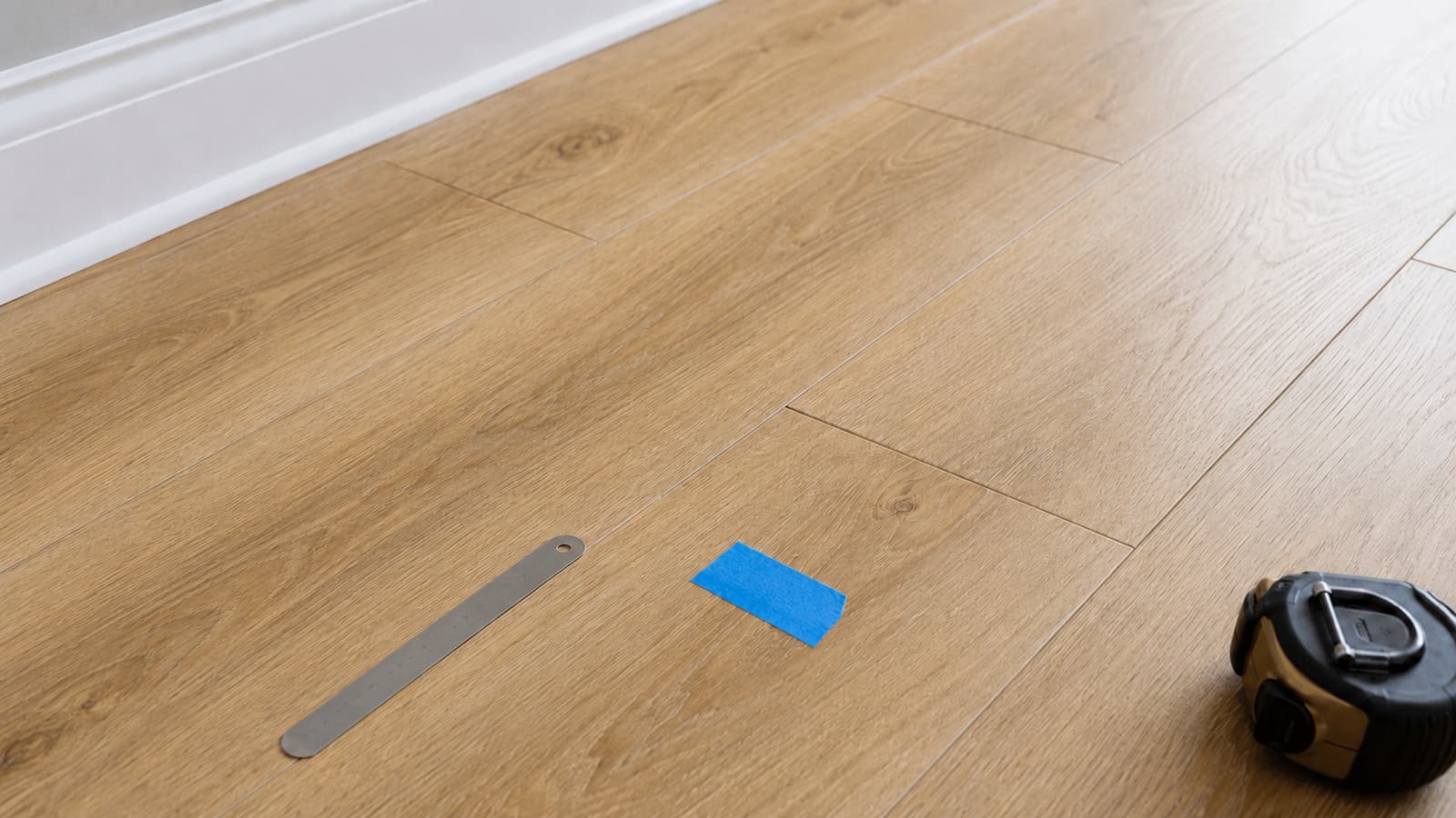Close-up of a separated end joint in wood-look LVP flooring during inspection